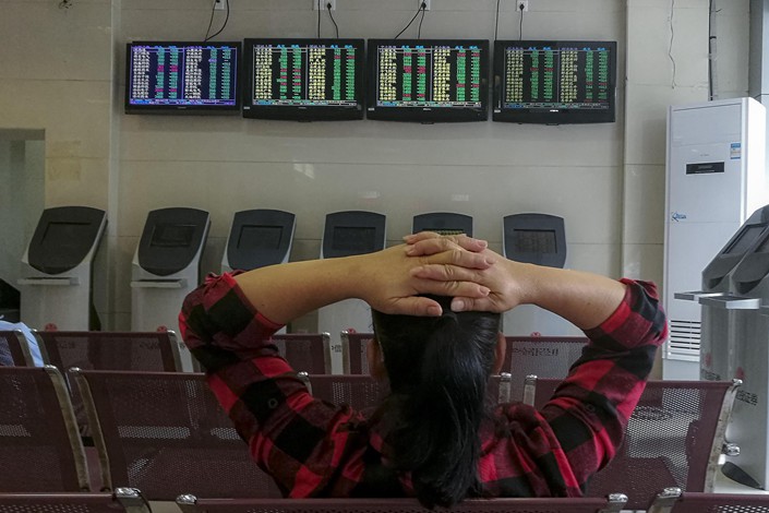 A woman sits in the client area of a securities trading company in Haikou, Hainan province on Oct. 18. Photo: VCG