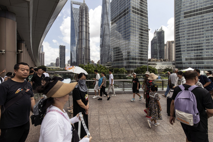 Pedestrians walk through the Lujiazui financial district in Shanghai on Aug. 5. Photo: Bloomberg