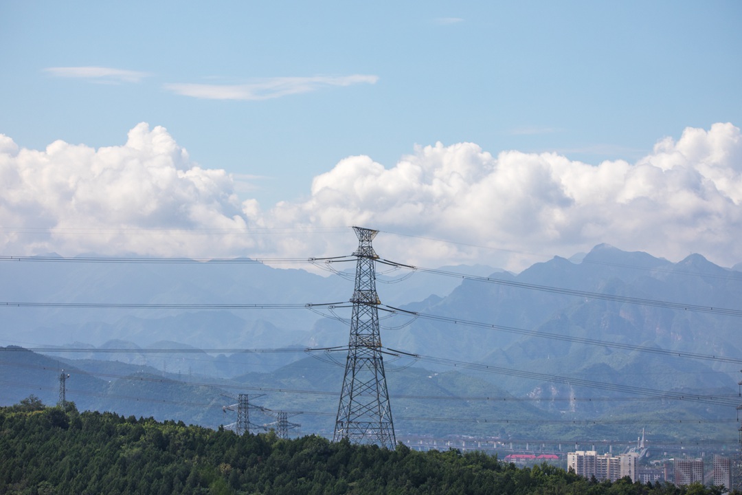 A high-voltage electricity tower stands against the mountains around Beijing in August 2022. Photo: VCG