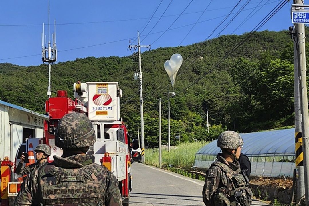 Balloons with trash presumed to be sent from North Korea hang on electricity wires Wednesday as South Korean soldiers stand guard in Muju, South Korea. Photo: VCG