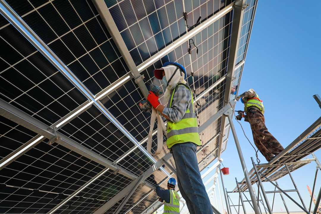 Workers install solar panels at a solar farm in Jiuquan, Gansu province, on May 11. Photo: VCG